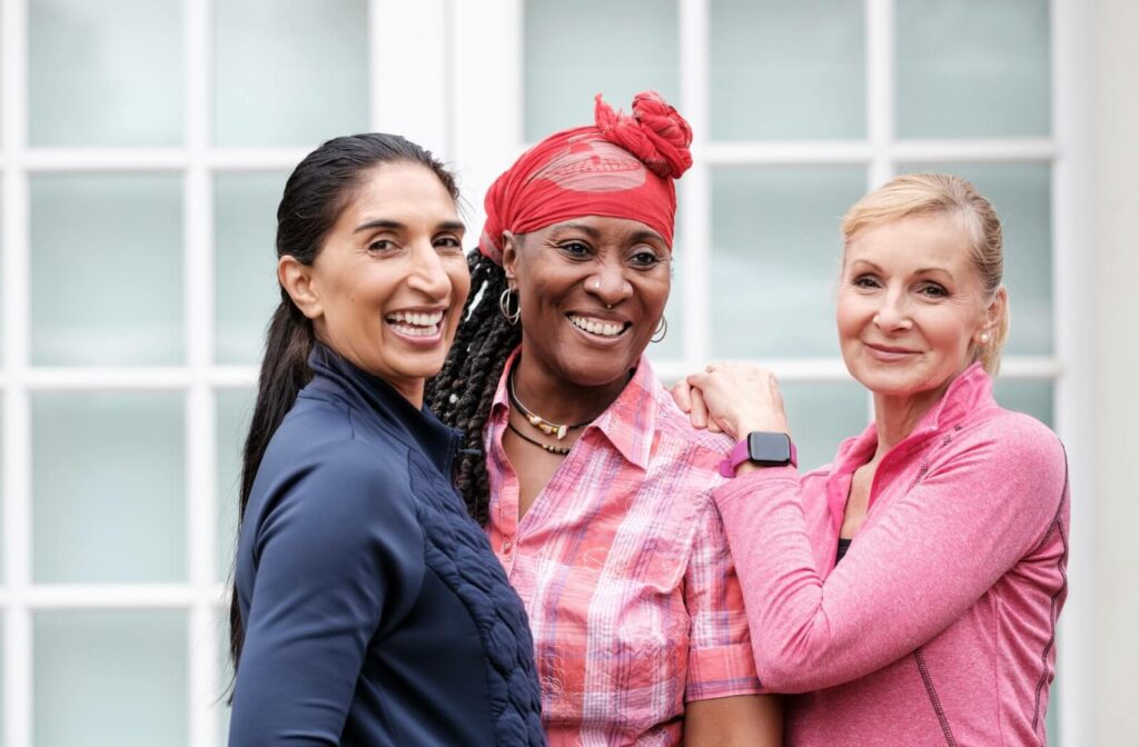 Multicultural mature women hugging and posing for the camera.