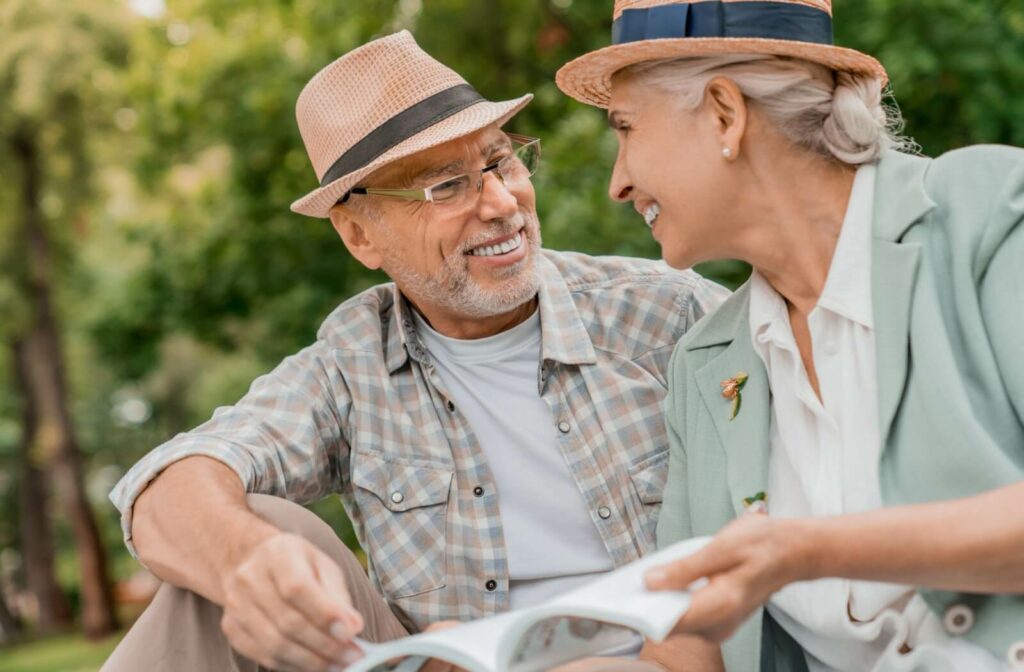 A senior couple enjoys time together outdoors, smiling at each other.